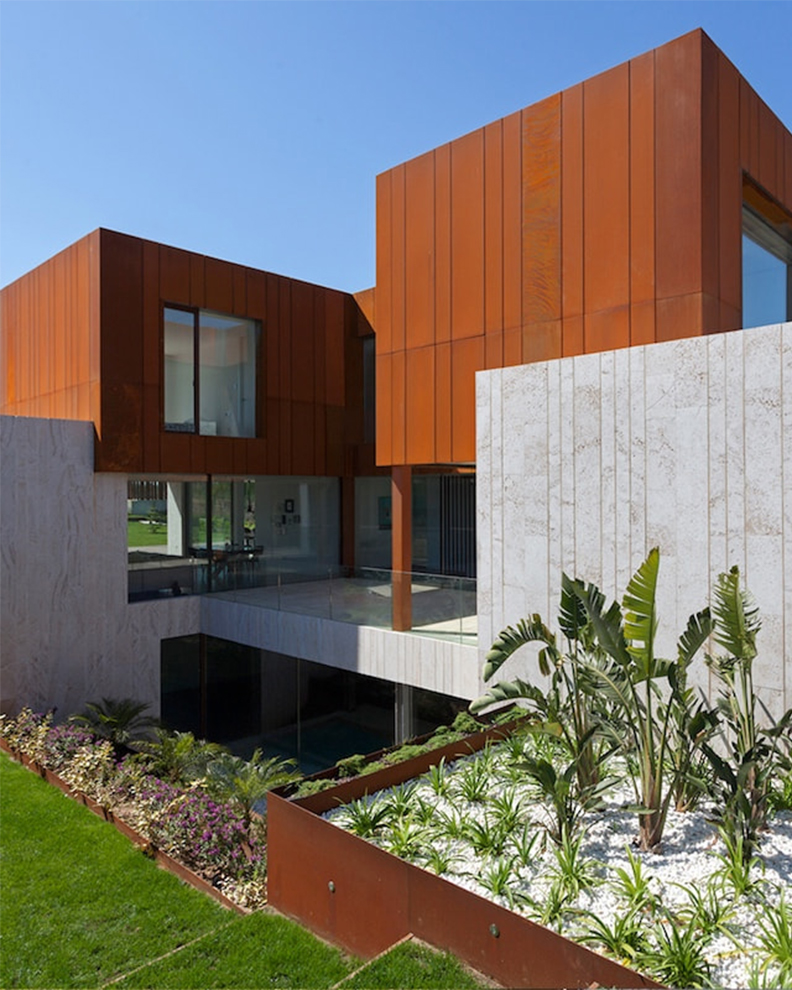 Façade de villa contemporaine habillée de panneaux en acier Corten au Maroc, alliant design architectural moderne, durabilité et finition naturelle.