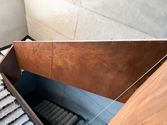 Habillage architectural d’un escalier intérieur en acier Corten Maroc avec panneaux métalliques patinés