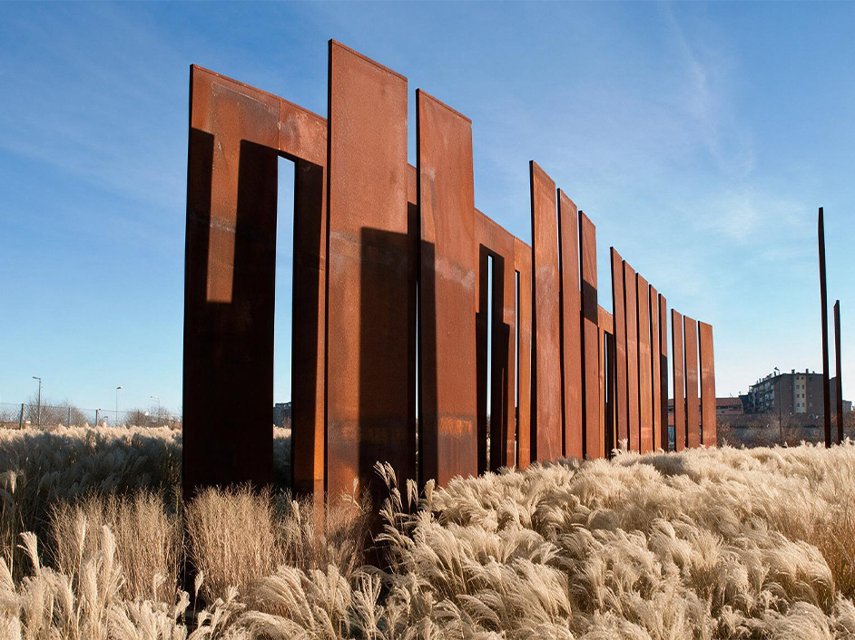 L’acier Corten utilisé pour une installation architecturale composée de panneaux verticaux dans un paysage contemporain