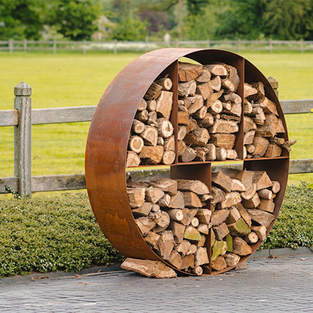 L’acier Corten utilisé pour un range-bûches circulaire installé dans un jardin extérieur contemporain