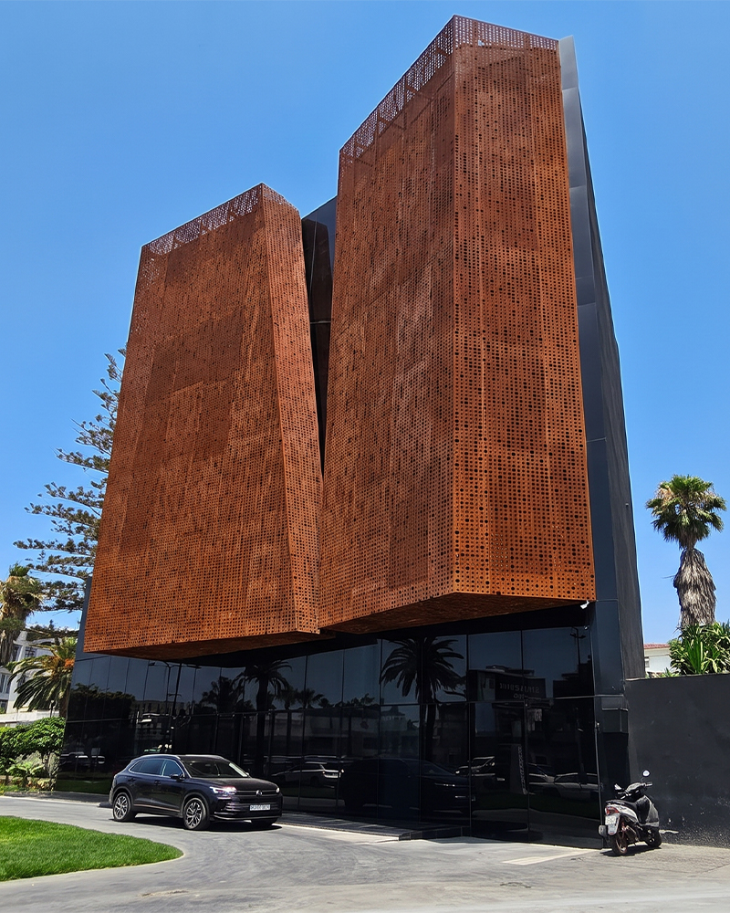 Façade perforée en acier Corten Maroc installée sur un bâtiment contemporain avec panneaux métalliques de grande hauteur