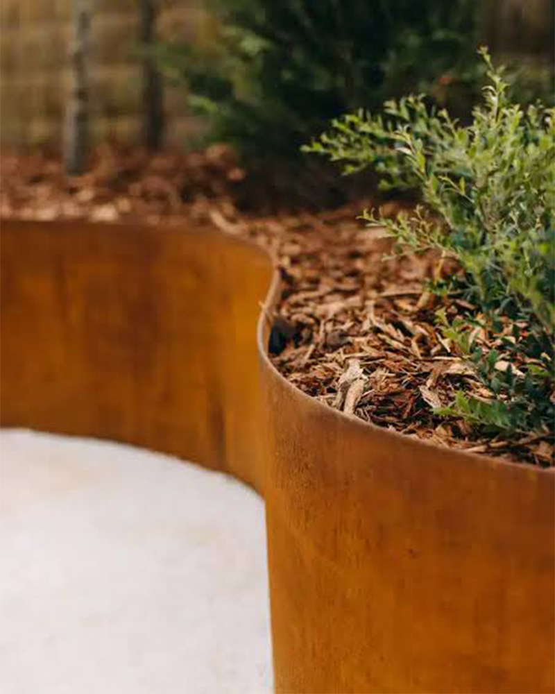 Projets en acier Corten avec jardinière courbe intégrée à un aménagement paysager contemporain au Maroc