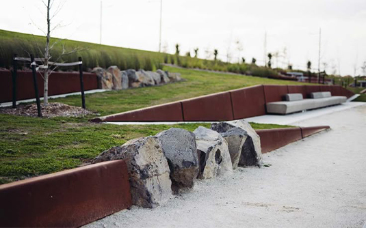 Projets en acier Corten avec bordures paysagères et éléments de retenue intégrés dans un parc contemporain