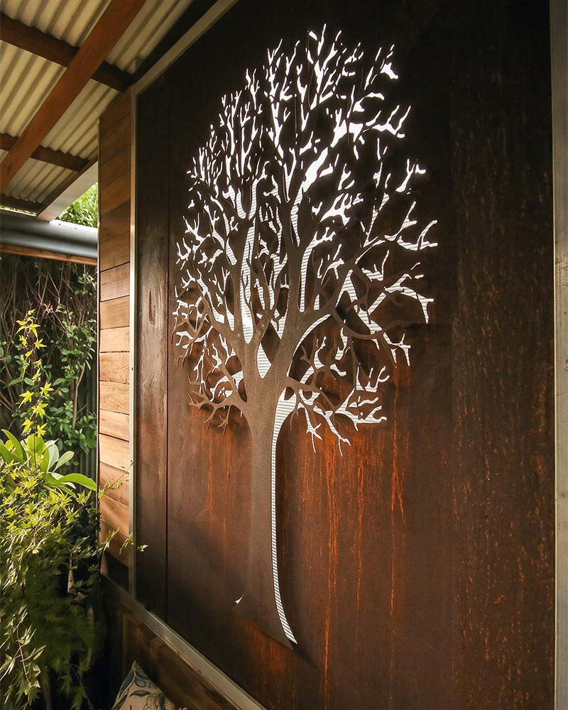 Projets en acier Corten avec panneau décoratif mural découpé en forme d’arbre dans un espace extérieur contemporain