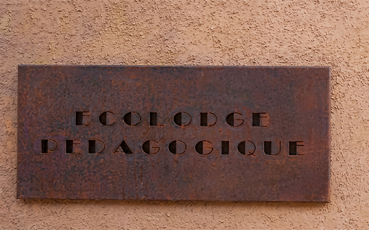 Projets en acier Corten avec plaque signalétique murale portant l’inscription Écolodge Pédagogique
