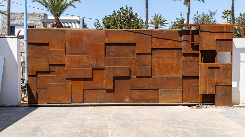 Réalisations en acier Corten au Maroc avec portail géométrique monumental installé à l’entrée d’une villa contemporaine au Maroc